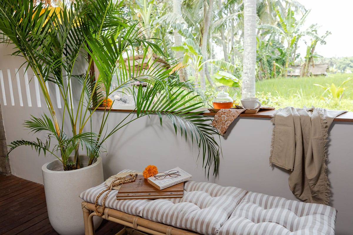 Scenic balcony view overlooking lush greenery and traditional Balinese architecture at a retreat in Ubud, Bali.